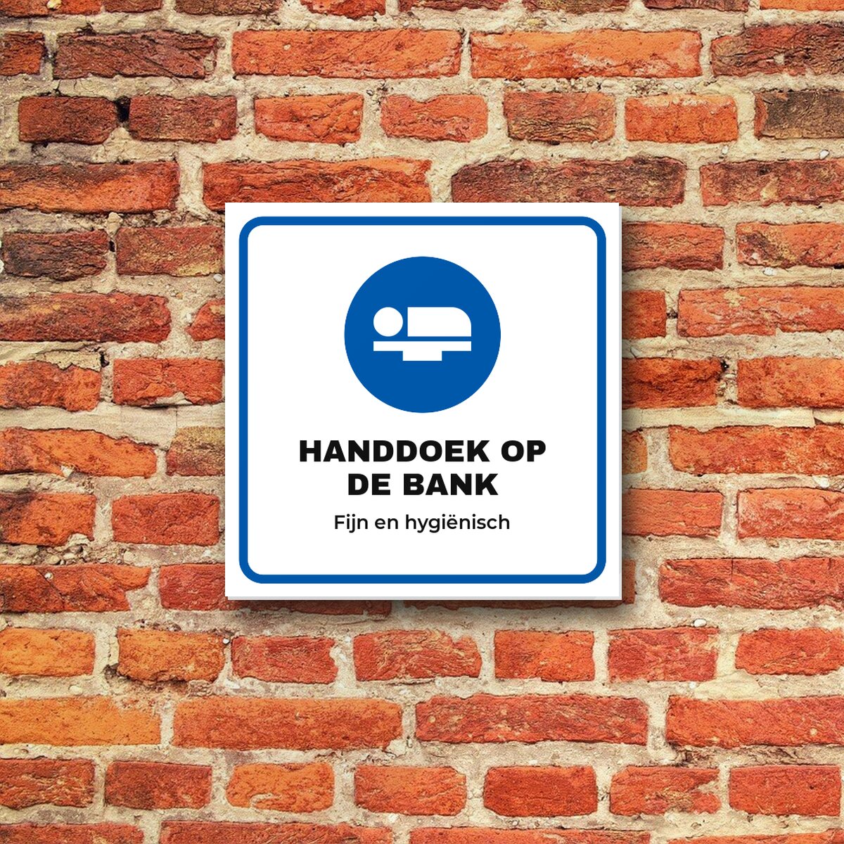 Bordje Handdoek op de behandelbank aan de muur