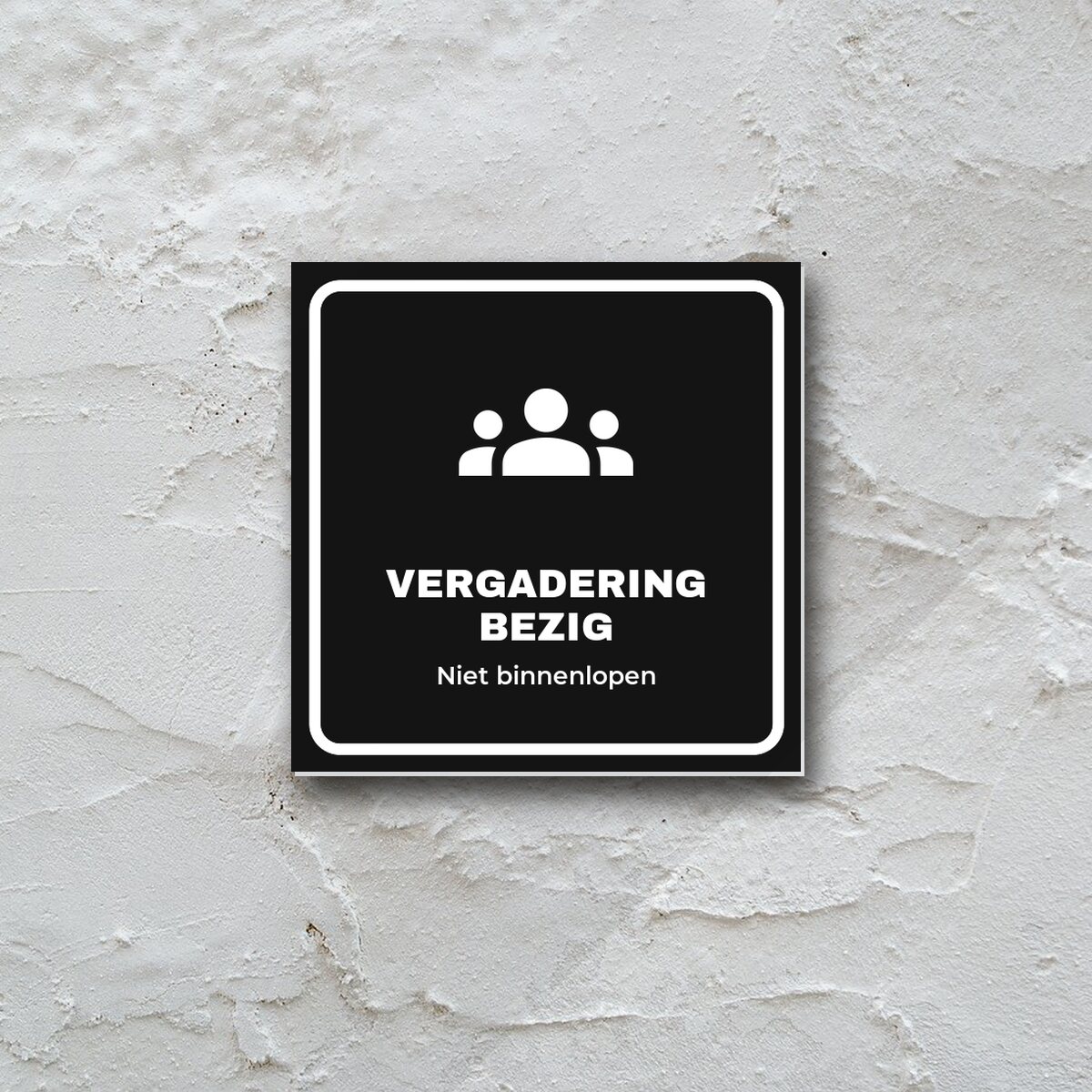 Deurbordje Vergadering bezig aan de muur